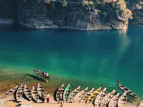 Wooden boats on the clear green water of the Umngot river at Dawki, Meghalaya